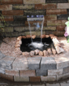 kleiner Wasserfall aus Steinwand in Brunnen
