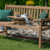 Gartenbank aus Holz mit Tablett und grünen Kissen
