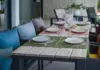 gedeckter Gartentisch mit Stühlen und farbenfrohen Aufsetzern
